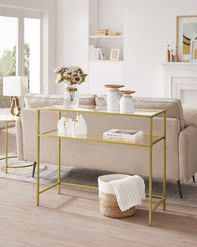 Gold console table behind a cream sofa in a bright living room