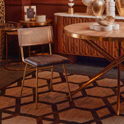 Gold fir wood round dining table in a living and dining space with plants and decor