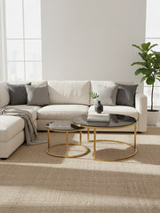 Gold and glass round nesting coffee tables styled in a living room setting