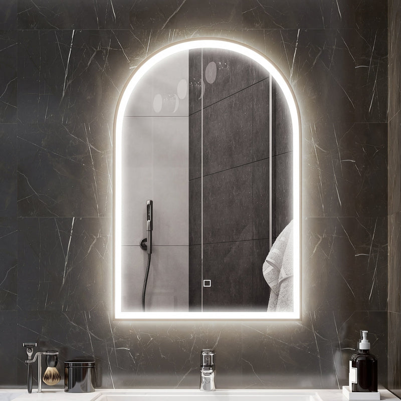 Lit arched bathroom mirror on a dark marble wall