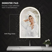 Woman with a towel on her head at the mirror, with the anti-fog demister area labelled