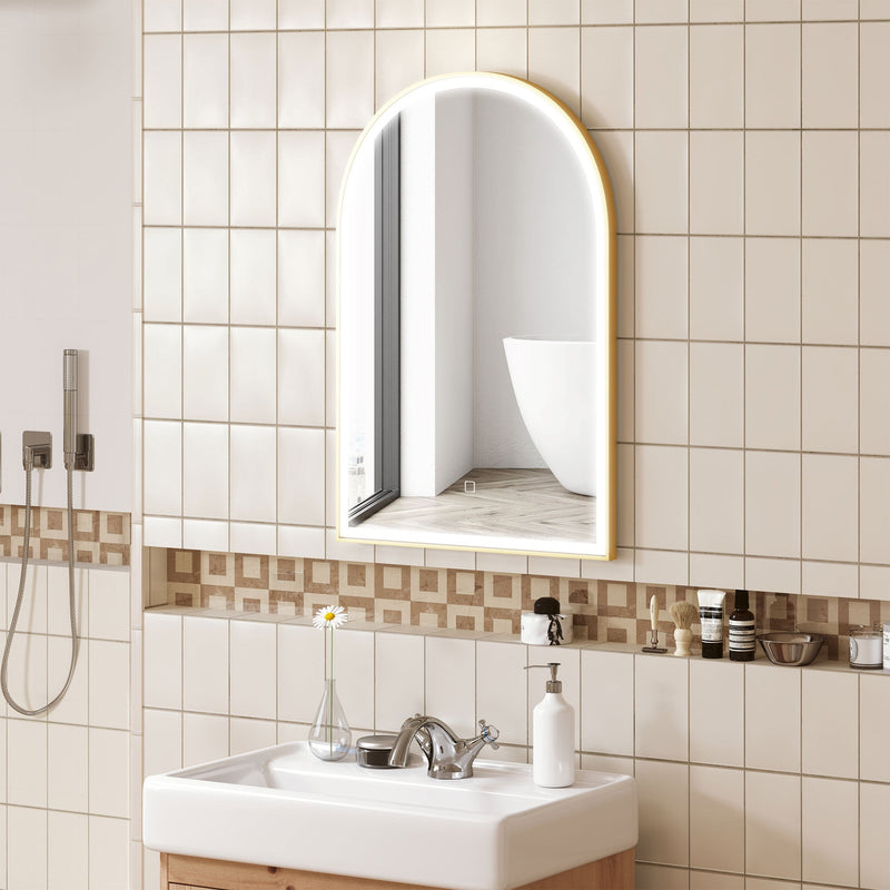 Lit arched mirror on a cream tiled bathroom wall above a white basin