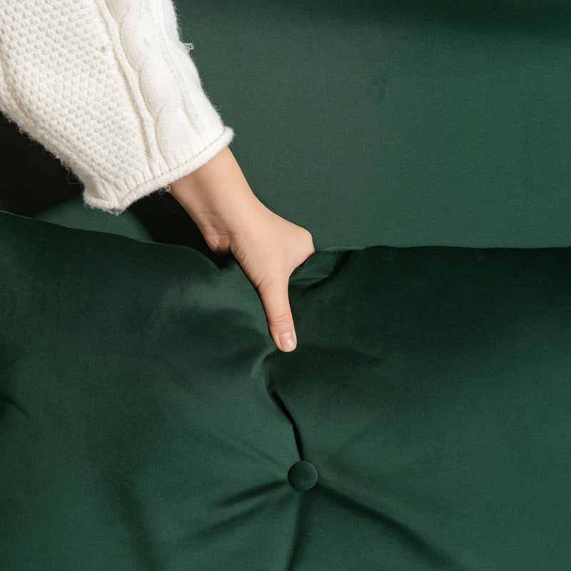 Close-up of a hand pressing into the tufted velvet cushion