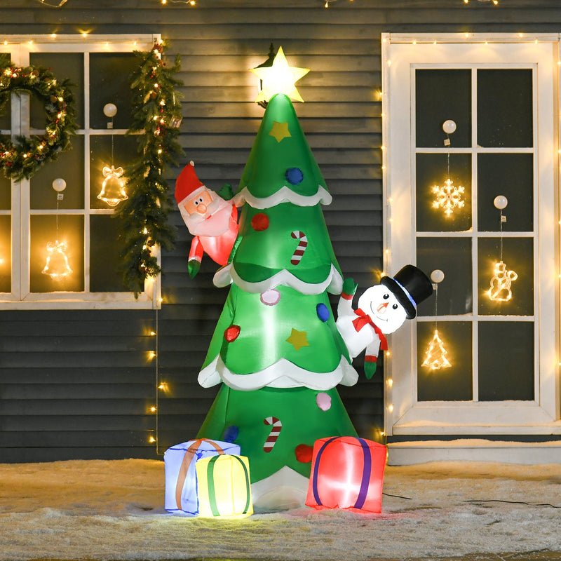 Lit inflatable Christmas tree with Santa and snowman beside a house with fairy lights