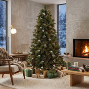6ft berry Christmas tree in a modern lounge with a fireplace, coffee table and wrapped gifts