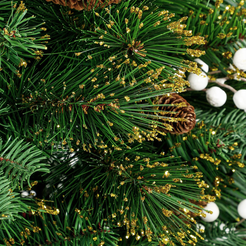 Macro close-up of pine needles with golden tips, white berries and a pine cone on the 6ft tree
