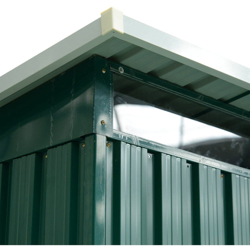 Corner detail showing the pent roof overhang above a clear polycarbonate panel and green ribbed cladding