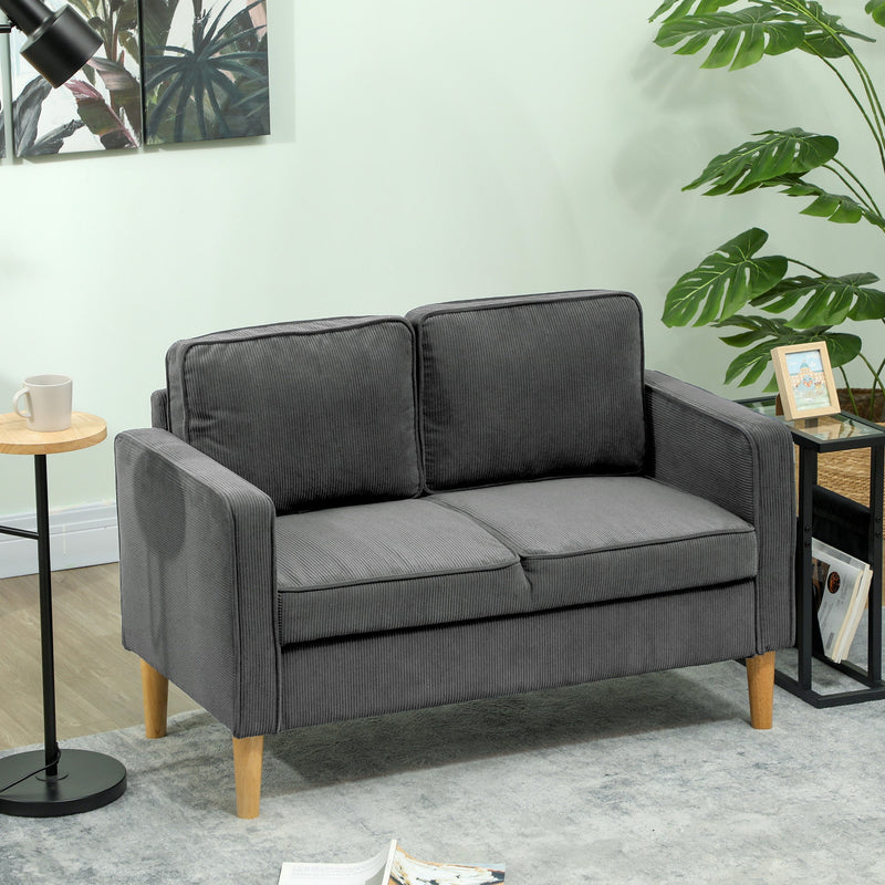 Grey corduroy sofa in a green-toned living room with a side table
