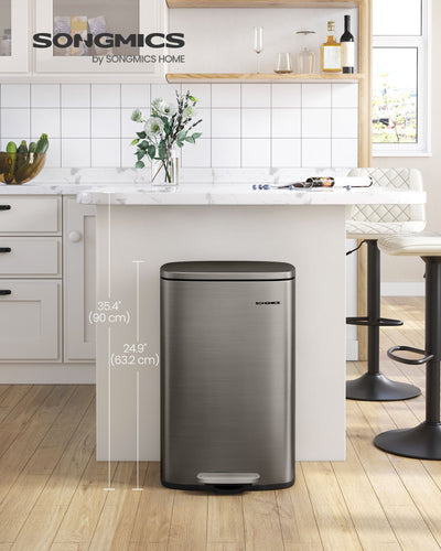Grey steel pedal bin standing next to a kitchen island