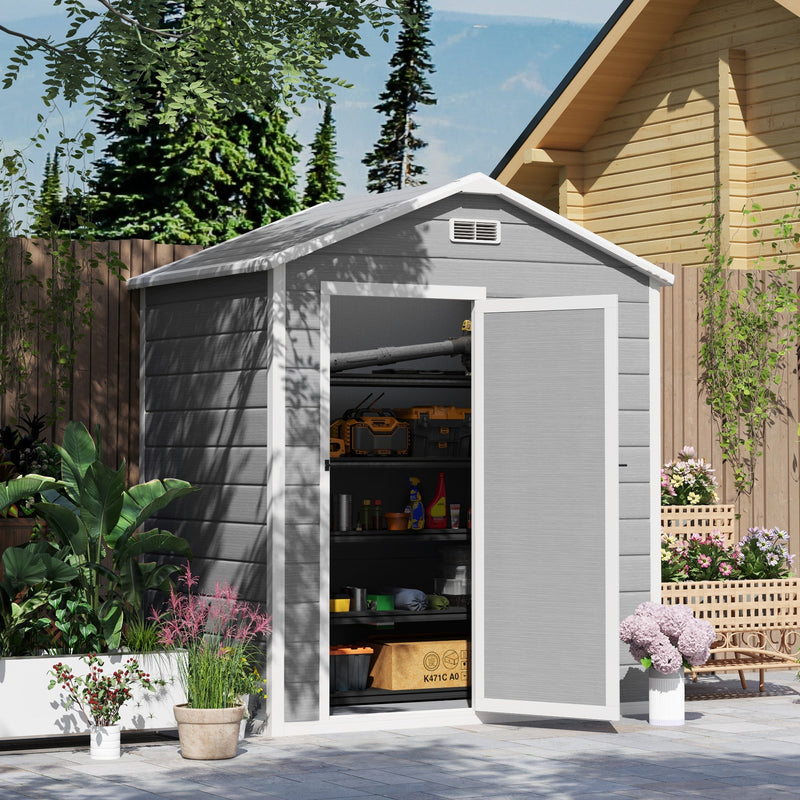 Plastic garden shed in a planted garden with the door open showing loaded interior shelving