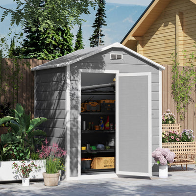 Plastic garden shed in a planted garden with the door open showing loaded interior shelving