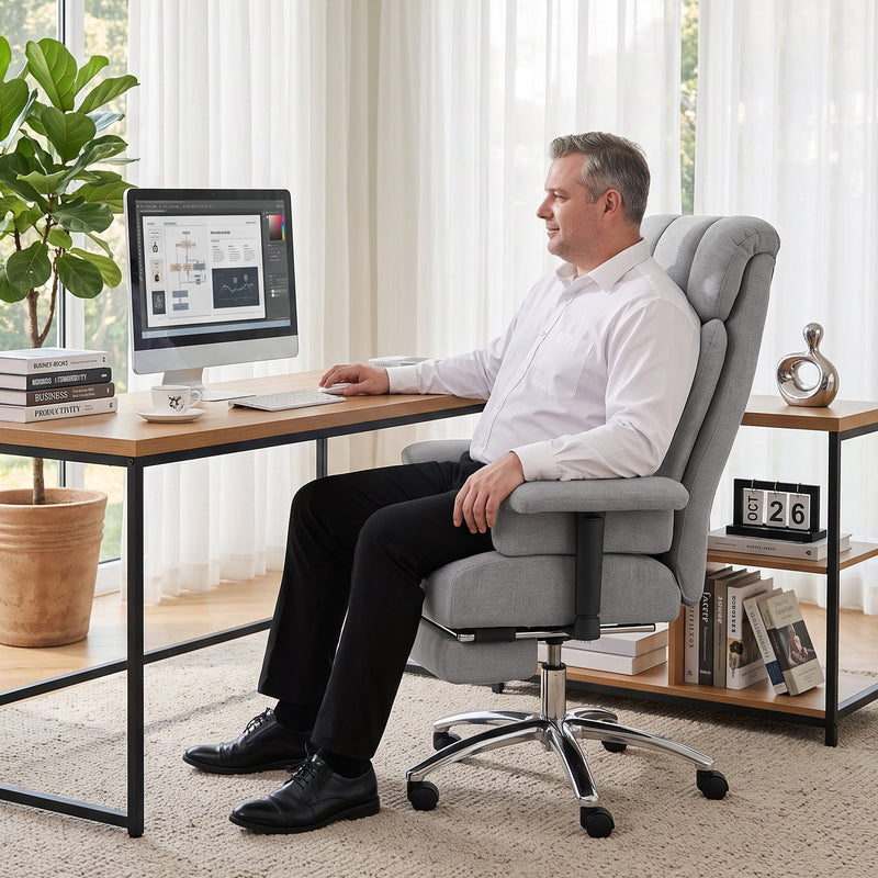 Man working at a desk in the upright grey office chair