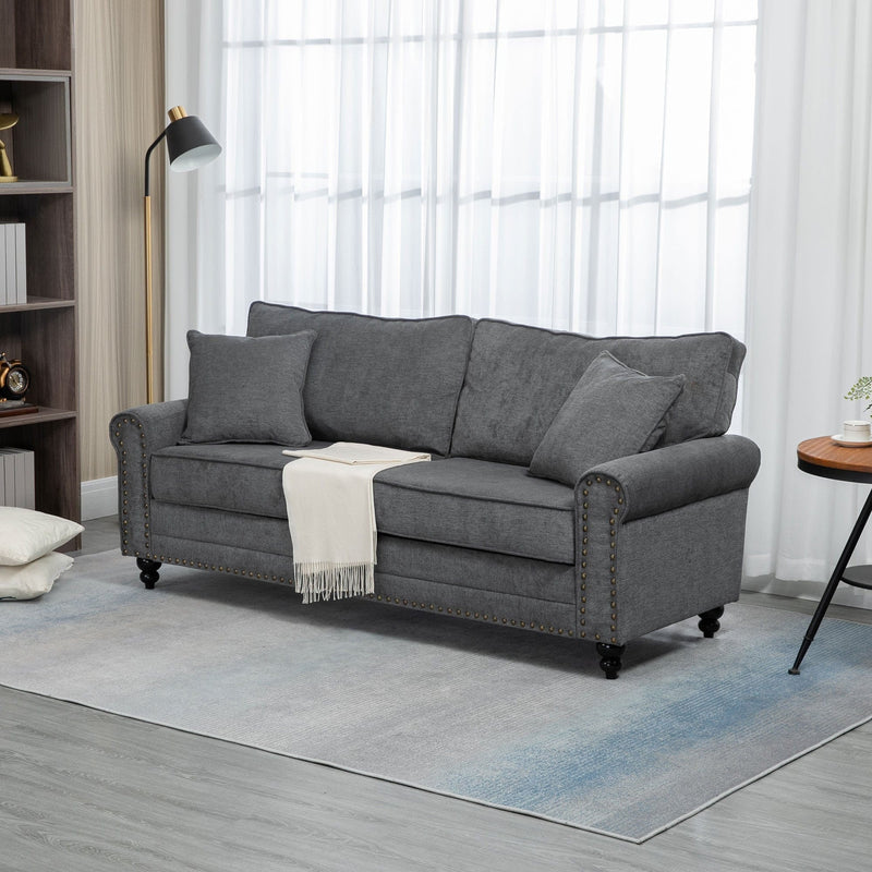 Grey fabric sofa styled in a living room with lamp and throw blanket