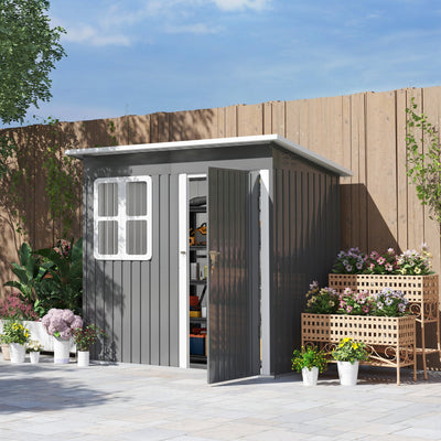 Dark grey 7x4ft metal garden shed on a paved garden patio with the door open, showing tools and boxes on the shelves inside