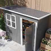 Raised view of the dark grey shed showing the sloping pent roof and the open door with tools inside