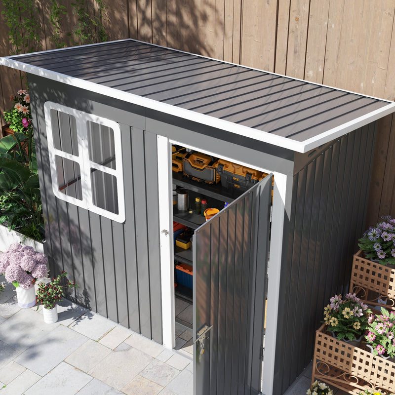 Raised view of the dark grey shed showing the sloping pent roof and the open door with tools inside