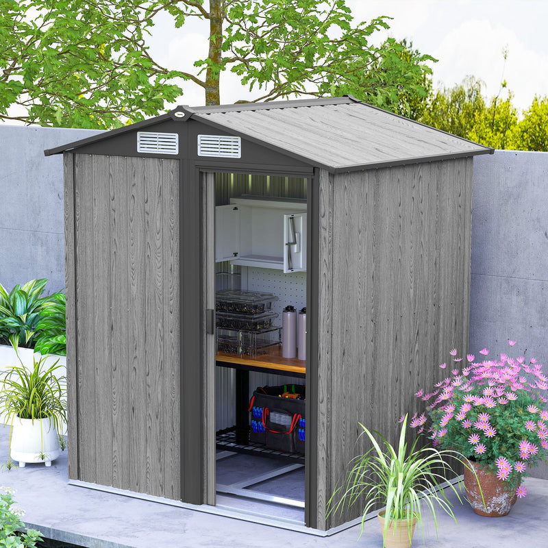 Grey wood effect shed with the sliding door open, showing a worktop and storage boxes inside