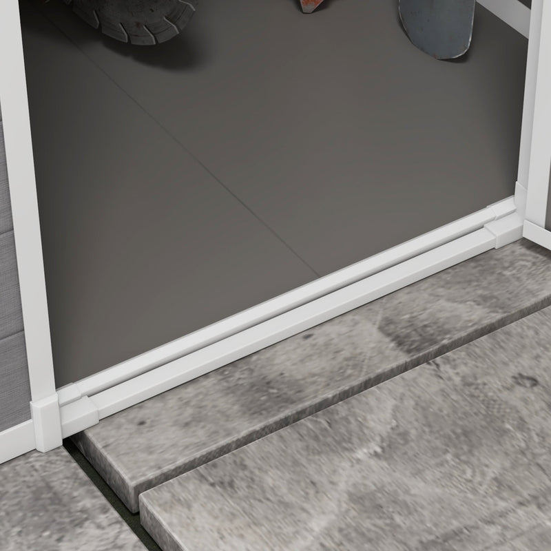 Close-up of the shed floor panel meeting the white door sill on stone paving