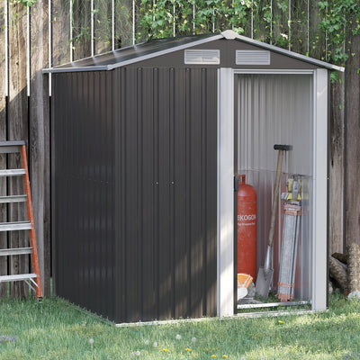 Grey metal garden shed against a wooden fence with the sliding door open, showing tools and a gas bottle stored inside