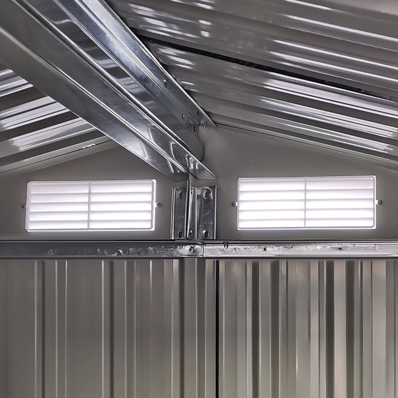 Inside the shed looking up at the apex roof frame and the 2 white louvre vents set into the gable