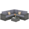 Grey rattan corner sofa set with grey cushions and glass coffee table on a white background