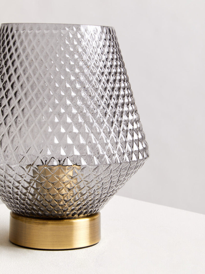 Grey smoked glass table lamp styled on a console