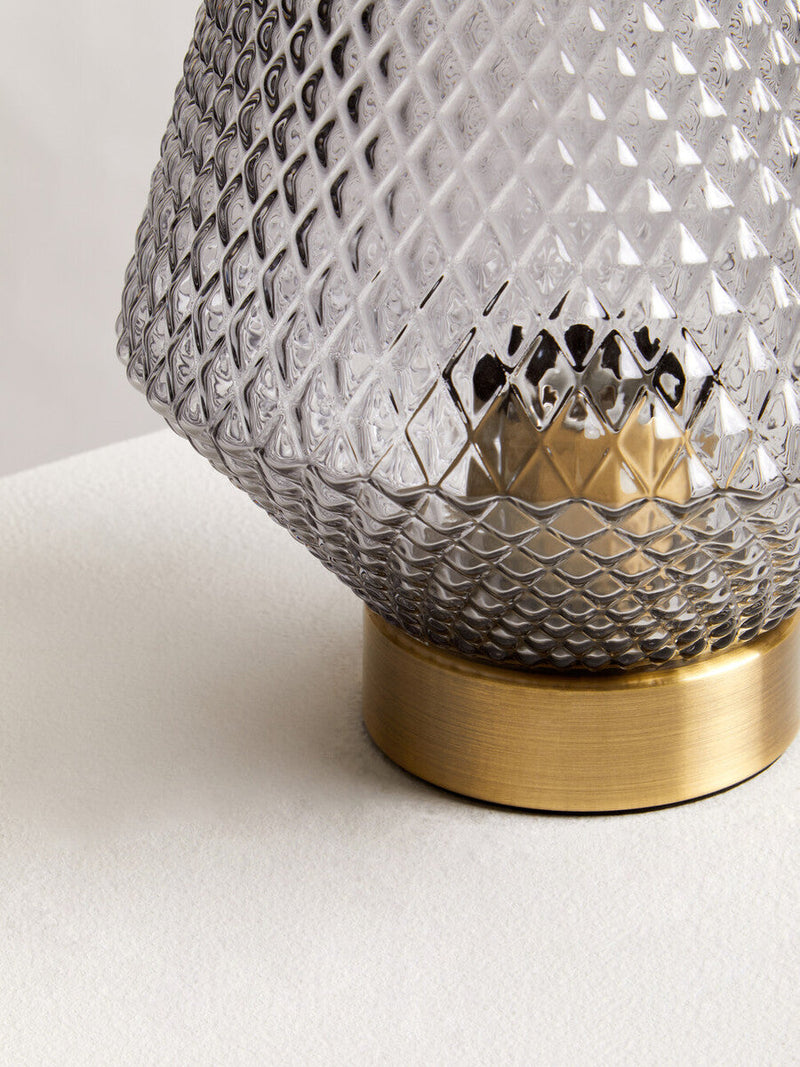 Grey smoked glass table lamp in a room setting