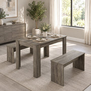 Dining set on a rug in a living room with a sideboard, plant and place settings