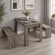 Dining set with place settings and a vase in a room with framed art