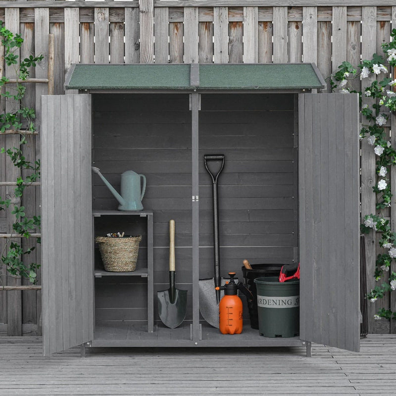 Grey wooden shed with both doors open against a fence with ivy and flowers