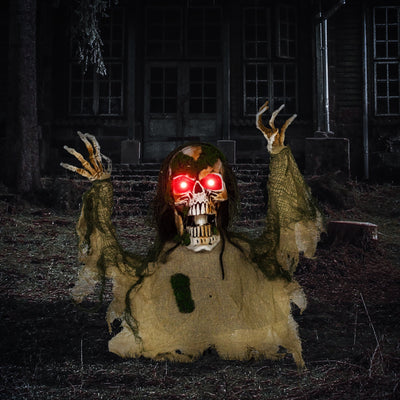 Half-body skeleton prop with glowing red eyes displayed outside a haunted house at night