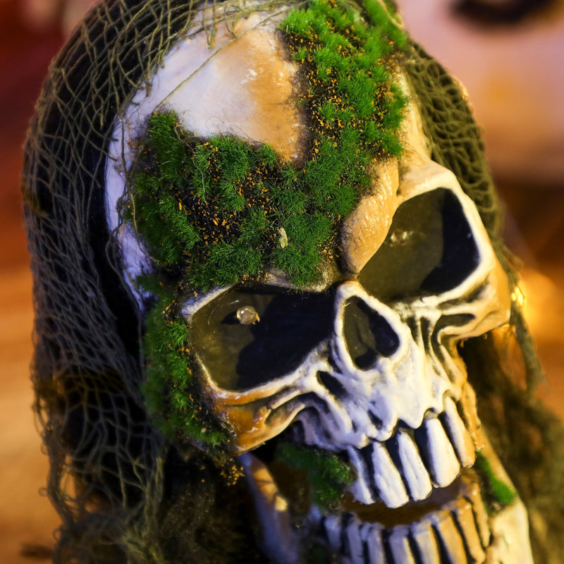 Close-up of the skeleton prop's moss-covered skull with weathered detailing