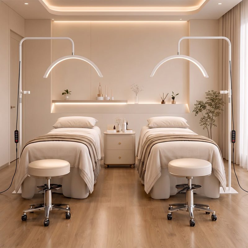 Two white half moon floor lamps either side of treatment beds in a spa room