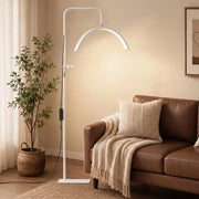 White half moon floor lamp beside a leather sofa in a living room