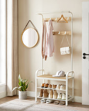 Hall tree in a hallway with coats, a handbag and a hanger on the hooks and shoes on the shelves