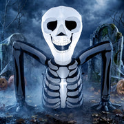Ground crawling skeleton inflatable lit up at night among gravestones and pumpkins