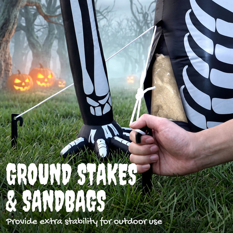 Close-up of the ground stake and rope anchoring the skeleton's arm in grass