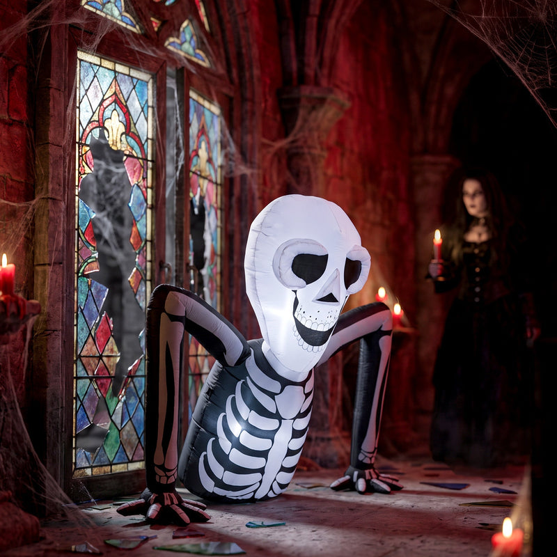 Skeleton inflatable displayed indoors in a gothic hallway with candles