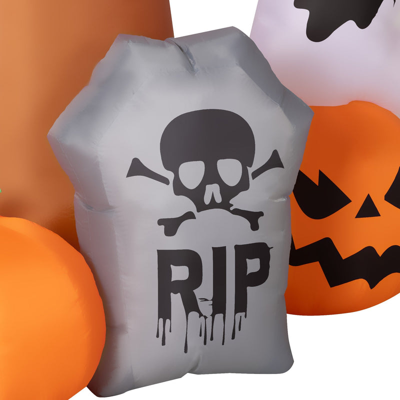 Close-up of the inflatable RIP tombstone and pumpkins beside the Outsunny Halloween tree