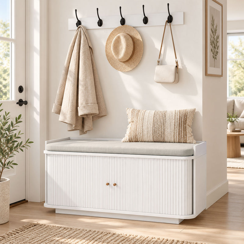 White hallway set in a styled entryway with a coat, straw hat and cross-body bag hanging
