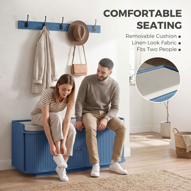 Two people sitting on the blue shoe bench's removable linen-look cushion while putting on shoes