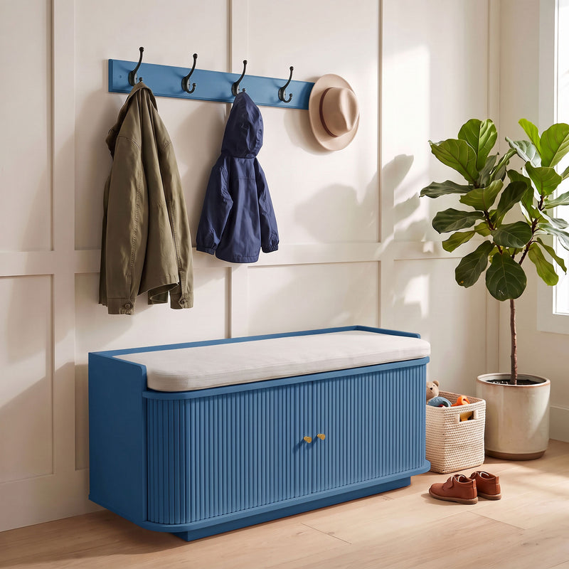 Blue hallway set styled with jackets on the hooks and a woven basket holding a toy beside the bench