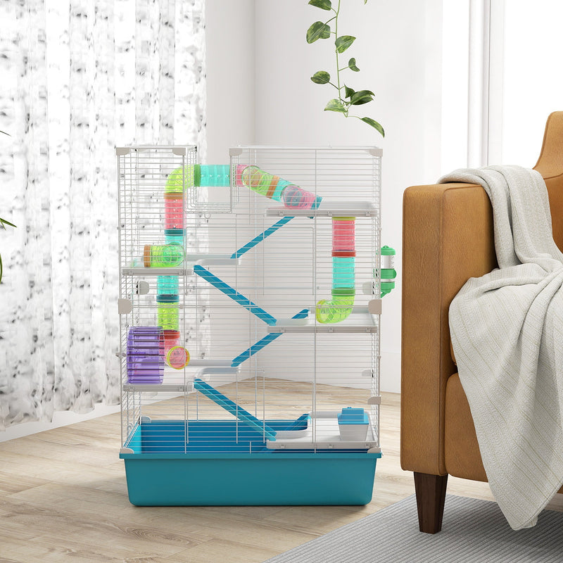 Light blue hamster cage styled beside a sofa with a throw blanket