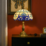 Lit table lamp on a sideboard in front of a framed butterfly print