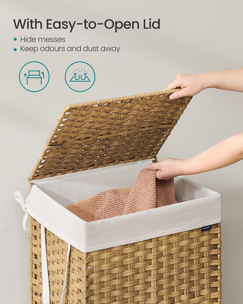 A hand lifting the hinged woven lid to drop clothing into the white liner inside the basket