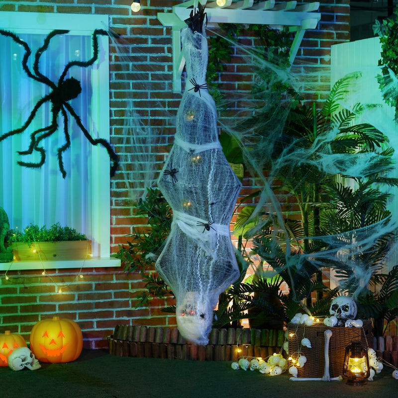 Cocoon corpse prop hanging from a pergola on a brick porch decorated for Halloween