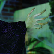 Close-up of the witch's pale clawed hand and black lace sleeve