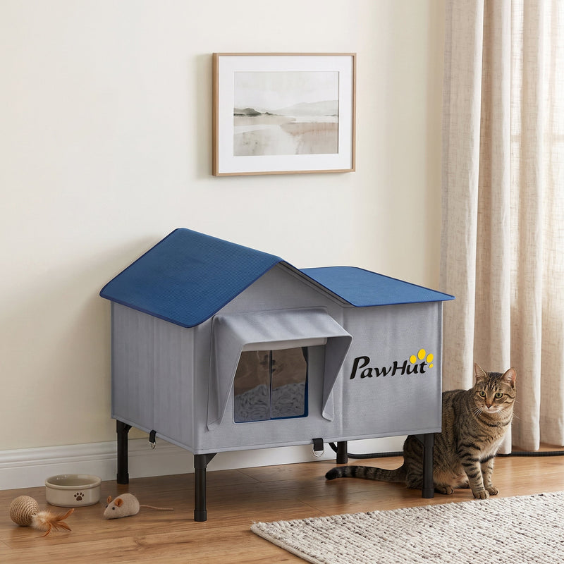 Cat house used indoors beside a rug with toys and a food bowl