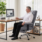 Man working at a desk with a computer while seated in the grey office chair
