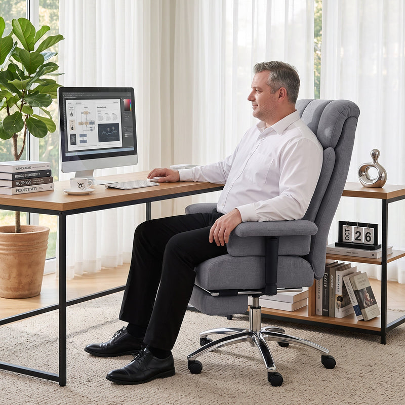 Man working at a desk with a computer while seated in the grey office chair